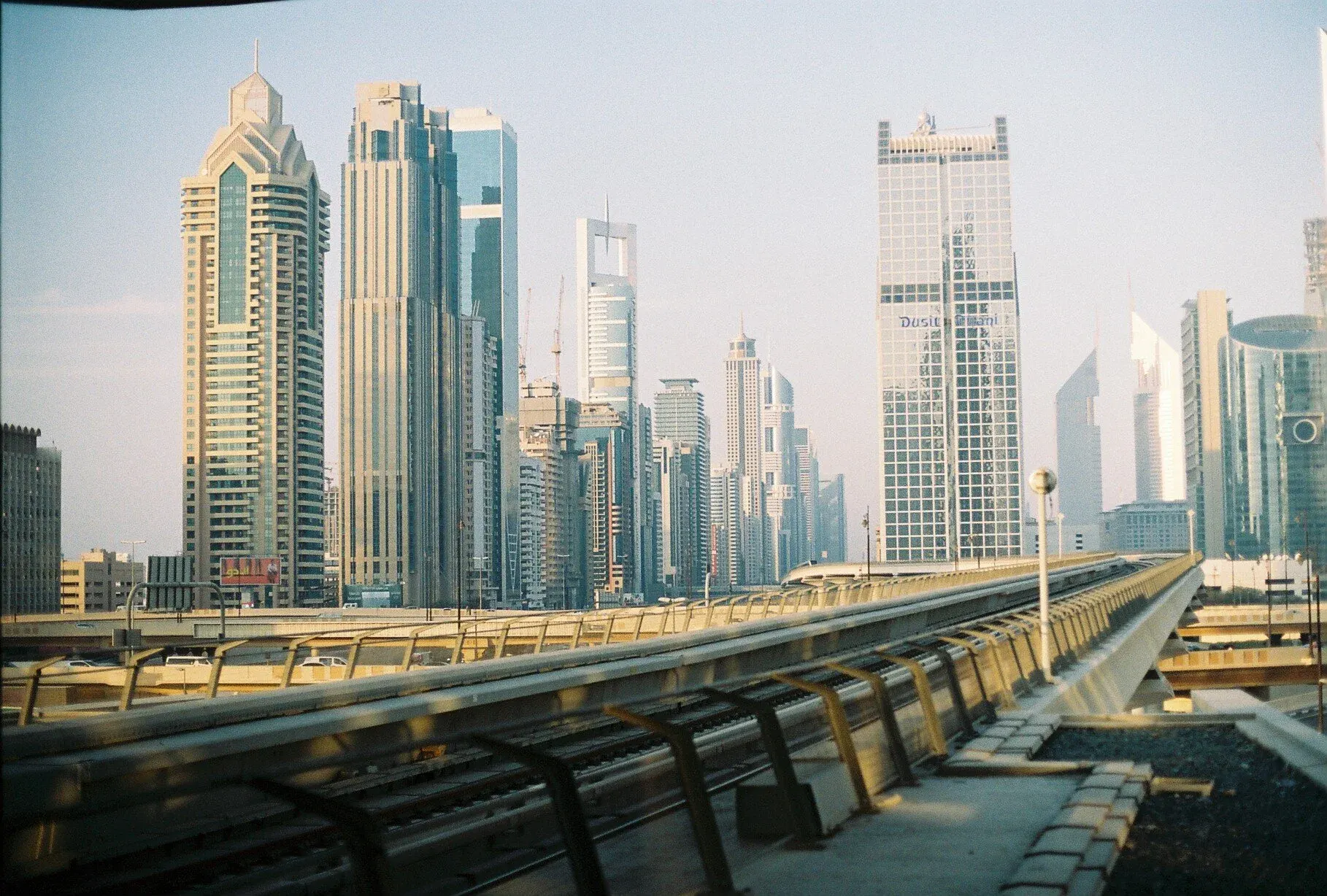 Une vue urbaine avec de nombreux gratte-ciel modernes et une voie de train en avant-plan, dans une ville moderne.