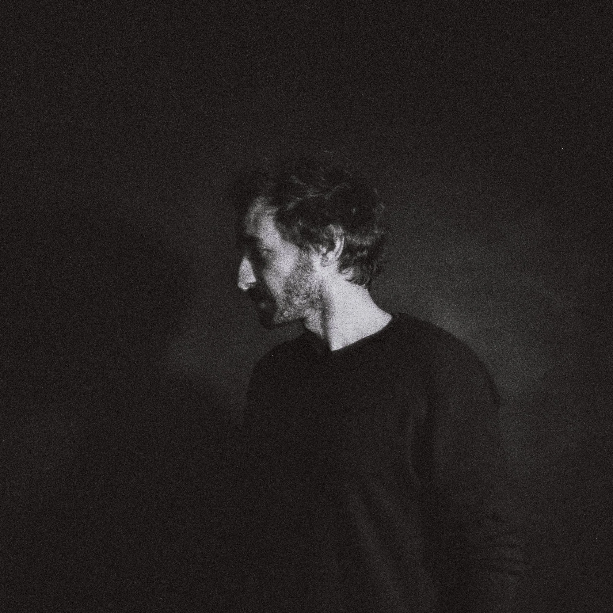 Portrait en noir et blanc de Greg Mattheus, de profil sur fond sombre